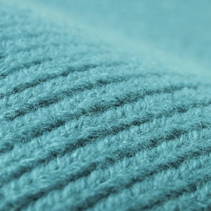 Close-up of teal rib-knit beanie showing soft wool texture and warm fabric detail