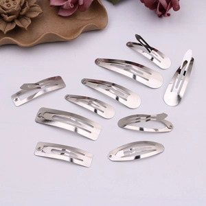 Detailed view of silver metal snap hair clips in various shapes like oval and rectangle