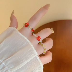 Close-up of handmade beaded floral stretch rings with colorful glass beads on a model's hand