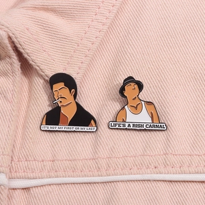 Detailed close-up of enamel pins with character illustrations on pink denim fabric