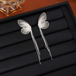 Detailed view of silver butterfly tassel earrings with sparkling rhinestones on black tray