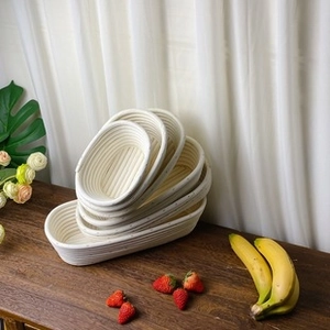 Detailed view of handmade oval rattan baskets in multiple sizes on a rustic wooden table