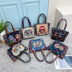Detailaufnahme bunter ethnischer Eulen- und Elefantenstickereien auf einer Canvas-Tasche
