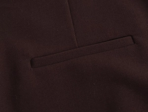 Nahaufnahme der gewebten Stoffstruktur und Taschennaht an einem braunen Blazer-Sakko