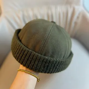 Detail of army green docker cap featuring canvas top and thick knit rolled brim