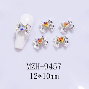 Close-up of 12x10mm silver alloy bow nail art charm with a heart-shaped crystal