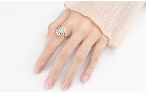 Close-up of spinning flower anxiety ring with sparkling crystals on female finger