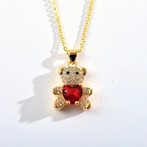 Detail of bear pendant with micro-pave zircons and a red heart stone on a gold chain