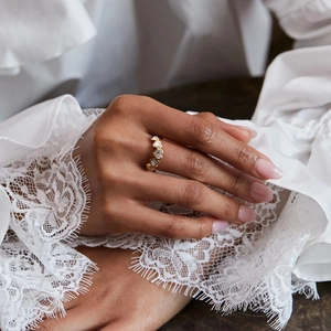 Primer plano de un anillo de oro con circonitas de corazón y elegante manga de encaje