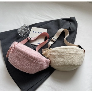 Detailed view of plush fleece belt bags in pink and beige with woven zipper pulls