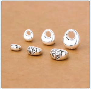 Macro shot of silver S925 solid beads with 福 character engraving for DIY jewelry