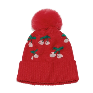 Detailed knit texture and cherry embroidery on the bright red winter beanie with pompom