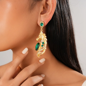 Close-up of vintage gold horse head earring with oval green gemstone and small diamonds