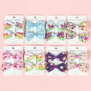 Close-up of 8 pairs of Easter bow hair clips with rabbits, eggs, and chick patterns