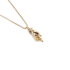 Gold-plated hand-shaped pendant necklace with cubic zirconia detailing on a box chain