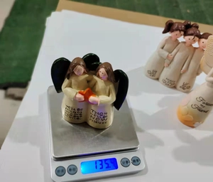 Detail showing weight measurement of resin friendship angel figurines with inscriptions