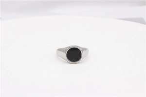Macro shot of silver signet ring with a round black enamel inlay and smooth polished finish