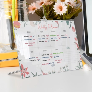 Detailed view of acrylic weekly planner with floral patterns and desktop metal stand