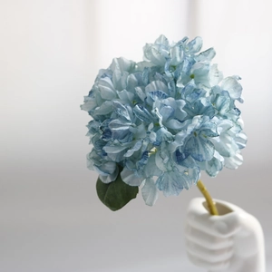 Detail of vintage blue artificial hydrangea petals with natural textures in a white vase