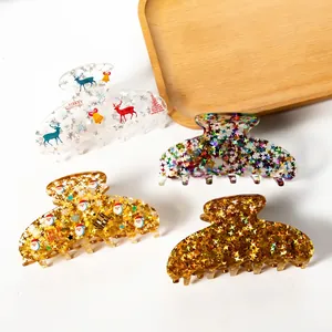Set of four acrylic Christmas hair claws with festive reindeer and snowflake patterns