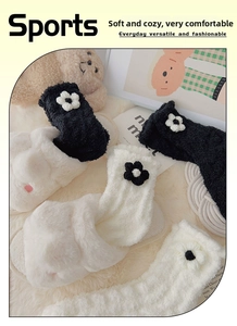 Details von weichen Korallenfleece-Blumensocken auf einem kuscheligen Heimteppich