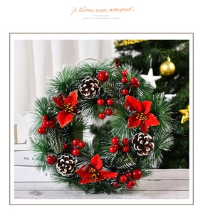 Corona de Navidad hecha a mano con flores de pascua rojas, bayas y piñas nevadas para puerta
