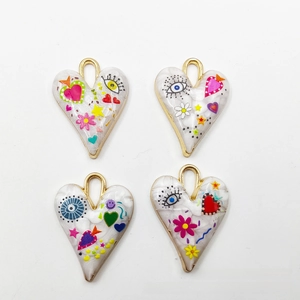 Detailed view of four heart-shaped pendants with colorful graffiti patterns and gold base