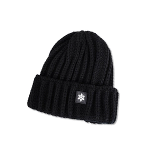Close-up of black chunky knit beanie featuring a white snowflake patch on the folded cuff