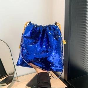 Detail of blue sequined bucket bag with gold chain strap and yellow tassel drawstring