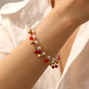Chic cherry fruit pearl chain bracelet with gold heart charms and red beads worn on wrist