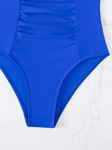 Detail of royal blue one-piece swimsuit featuring slimming ruched abdomen design
