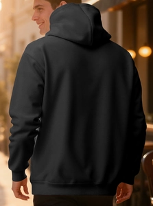 Men's oversized black hoodie with double-layer hood and ribbed cuffs on street background