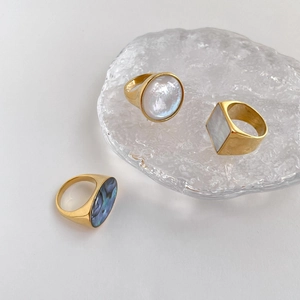 Close-up of geometric natural shell inlay rings in circular, square and oval shapes