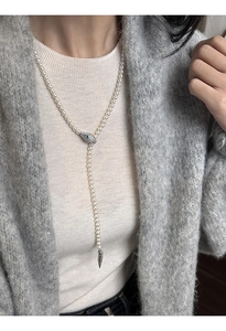 Detail of Y-shaped pearl necklace with emerald zircon snake head and silver tail charm