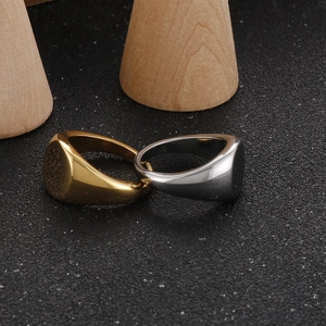 Detailed view of 18K gold and silver stainless steel signet rings on wooden cones