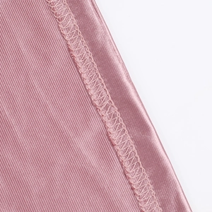 Detailed close-up of overlock stitching on pink satin evening dress fabric