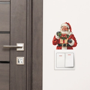 Detailed view of Santa Claus wall sticker placed over a light switch on a white wall