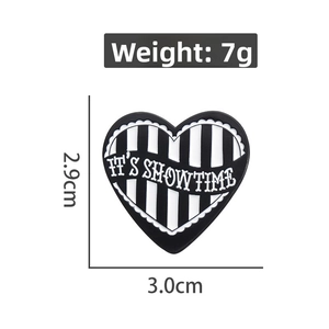 Detailed view of heart-shaped enamel brooch with black and white stripes and size markings