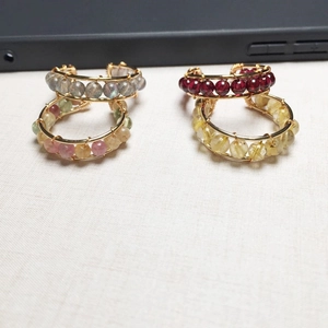 Detailed close-up of 14K gold filled wire wrapped rings with natural gemstones on beige fabric