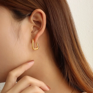 Minimalist 18K gold plated C-shaped earrings on model for a sophisticated jewelry look