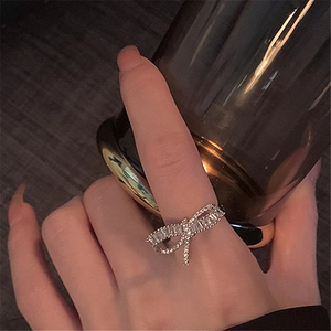 Detailed view of silver bow-shaped adjustable ring with baguette cubic zirconia stones