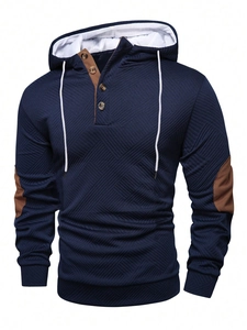 Detailed view of navy knit hoodie with brown patchwork and textured diamond pattern fabric
