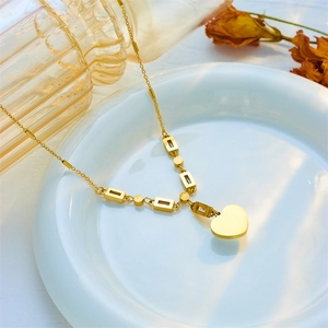 Elegant gold heart pendant necklace with rectangle links on a white plate