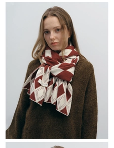 Close-up of red and white diamond pattern knit scarf with design brand label details