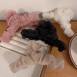 Set of large mesh fabric hair claws in pink, black, white, and beige on a tray