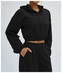 Detail of black sports set featuring high-waisted joggers with functional side pockets