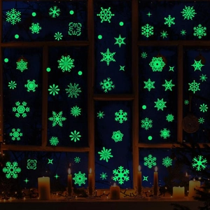 Autocollants de Noël flocons de neige verts luminescents sur fenêtre en bois de nuit