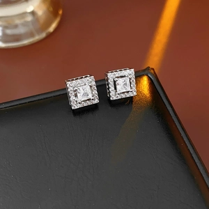 Close-up of square silver stud earrings with zirconia stones on black leather box