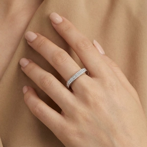 Gros plan d'une bague éternité argentée sertie de cristaux sur le doigt d'un mannequin
