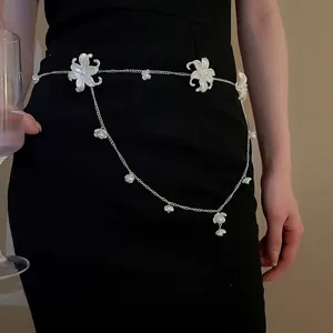 Elegant silver flower waist chain with pearl lily charms and tassels on a black dress